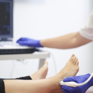 a physiotherapist performing an ultrasound on the ankle to check for injury