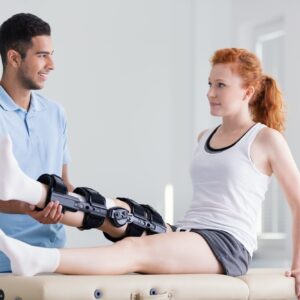 Young woman wearing a brace during rehabilitation with her physi